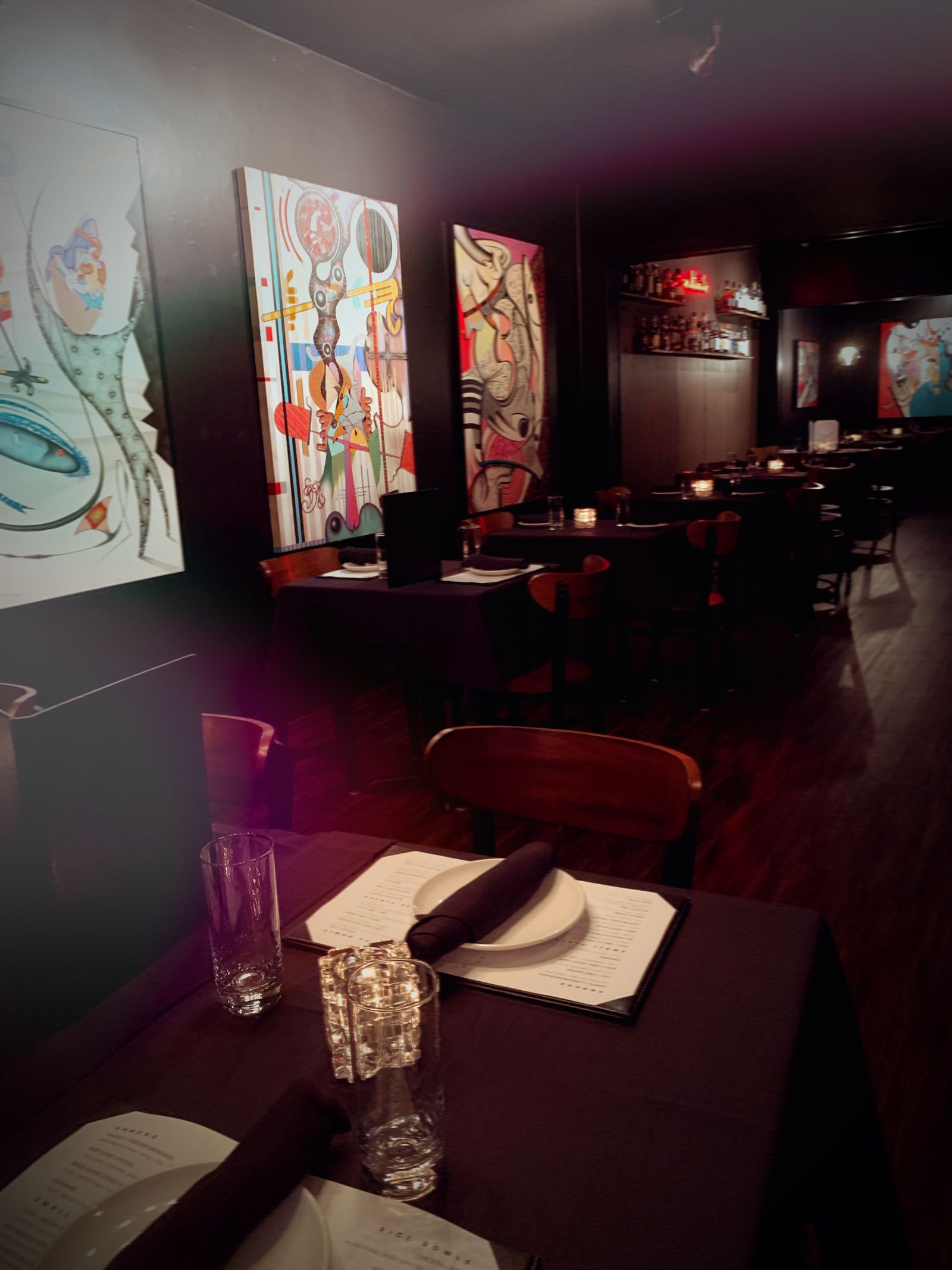 Lucky Duck dining room with art-lined black walls and candlelit tables